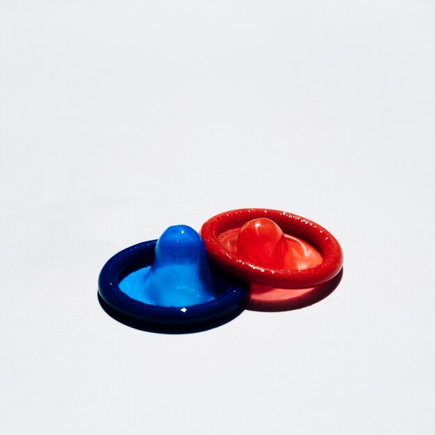 High angle red and blue condoms on white background 