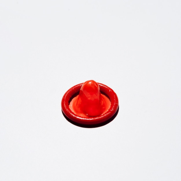 High angle red condom on white background