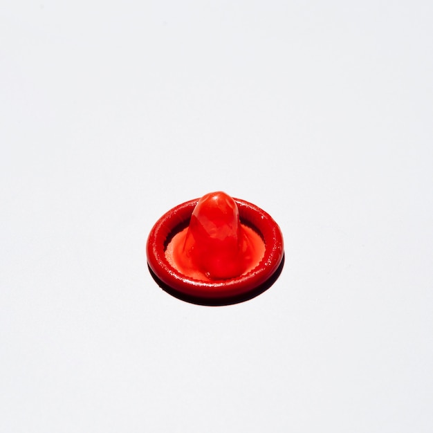 Высокий угол красный презерватив на белом фоне
