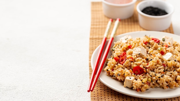 High angle rice with vegetables soy sauce and chopsticks with copy space