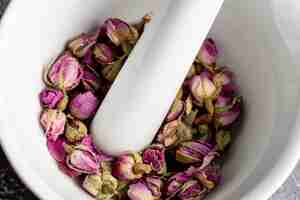 Free photo high angle of rose buds in mortar with pestle