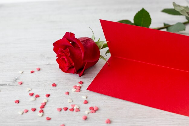 High angle of rose with paper and hearts for valentines day