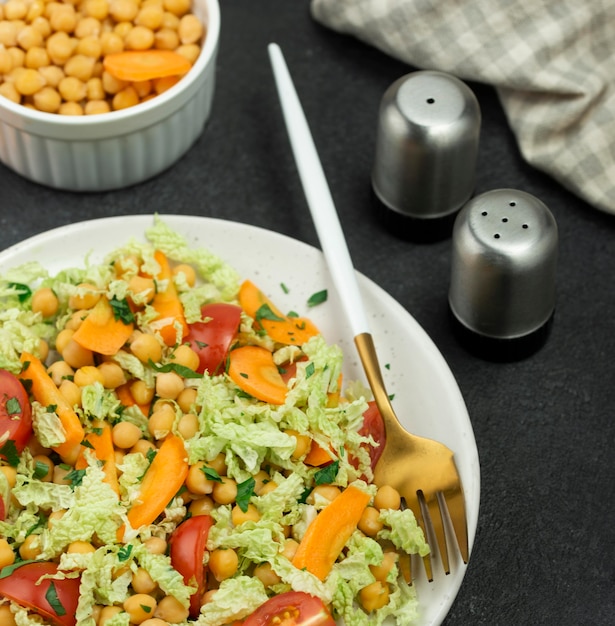 High angle salad with chickpeas and salt and pepper shakers
