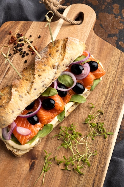 High angle of salmon sandwich with olives and onions