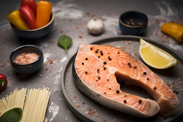 Free photo high angle salmon steak on tray with ingredients