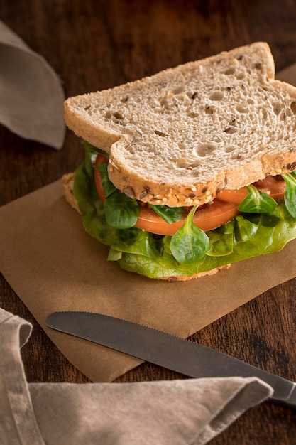 High angle of sandwich with greens and tomatoes