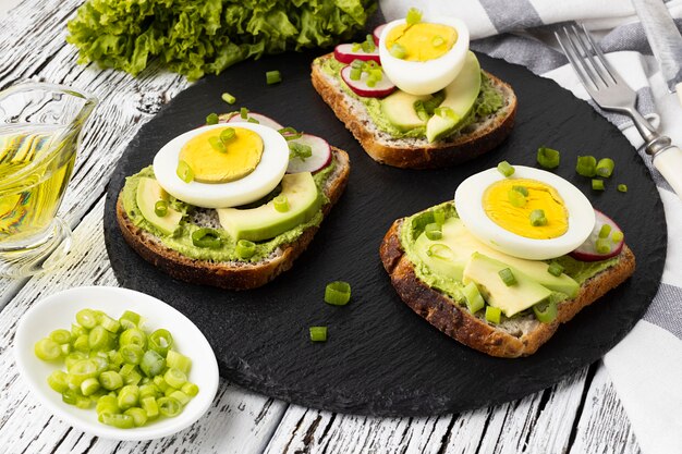 High angle of sandwiches on slate with egg and avocado