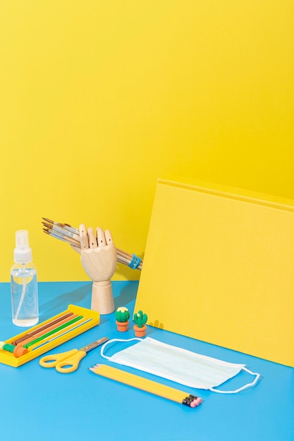 High angle of school supplies with face mask and pencils