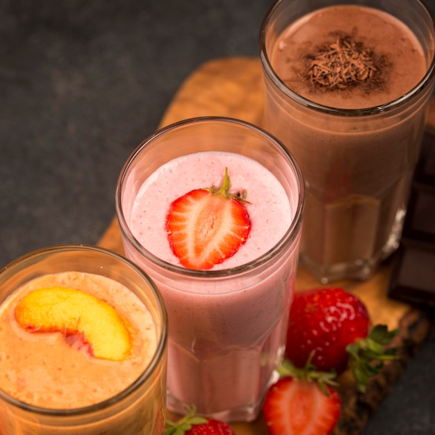High angle of selection of milkshake glasses with chocolate and fruit