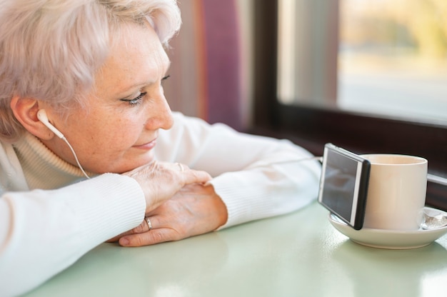 High angle senior female watching videos on phone