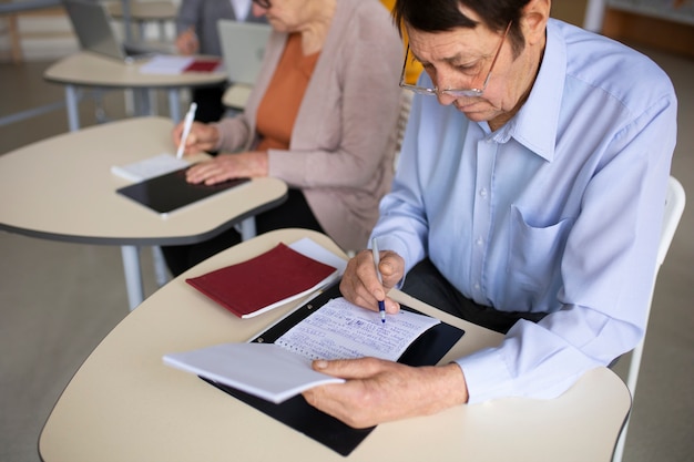 Free photo high angle senior people studying in classroom