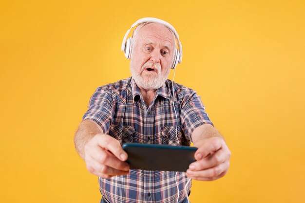 High angle senior playing music on phone