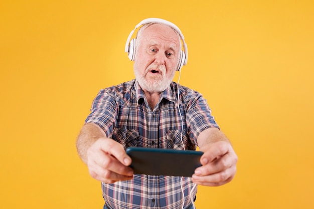 High angle senior playing music on phone