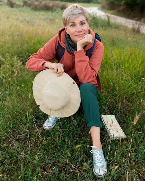 High angle of senior tourist woman in nature with hat