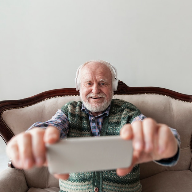 High angle senior watching video music