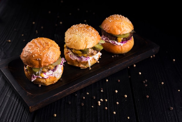 High angle set of burgers on a wooden board