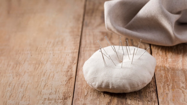 High angle of sewing needles with textile and copy space