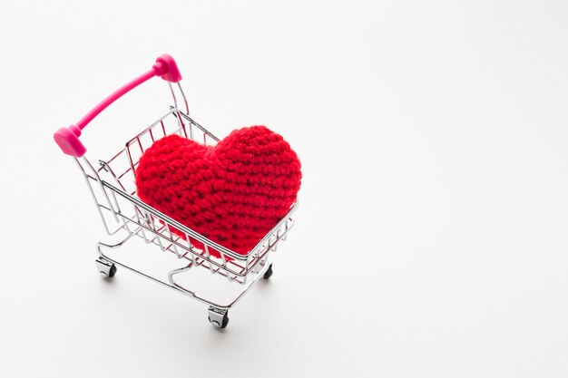 High angle of shopping cart with valentines day ornament