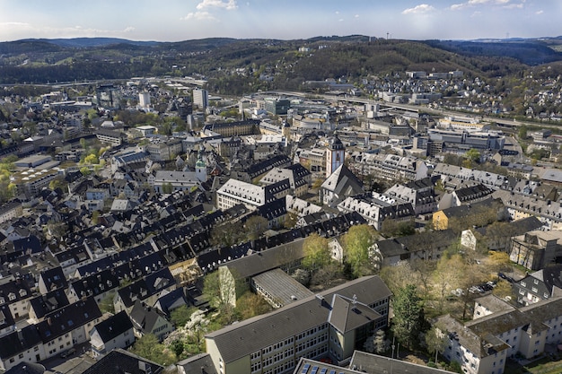 High angle shot of a beautiful city surrounded by hills under the blue sky