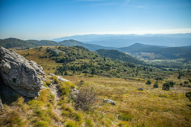 슬로베니아의 푸른 하늘 아래 숲과 아름다운 산의 높은 각도 샷