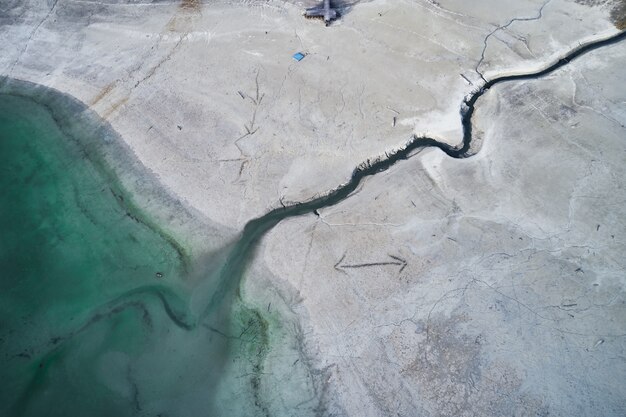 High angle shot of a big crack on the stony shore next to the turquoise water