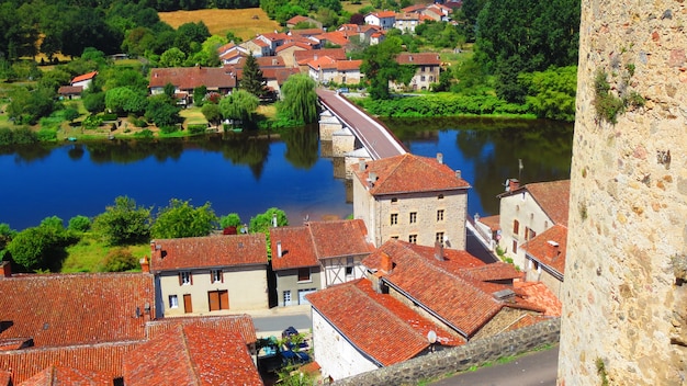 High angle shot of a a bridge and red roofed buildings along a river