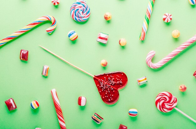 High angle shot of candy canes and lollipops on green