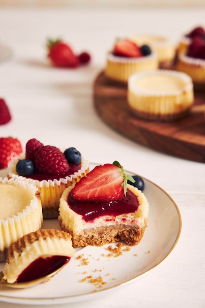 High angle shot of cheese cupcakes with fruit jelly and fruits on a wooden plate