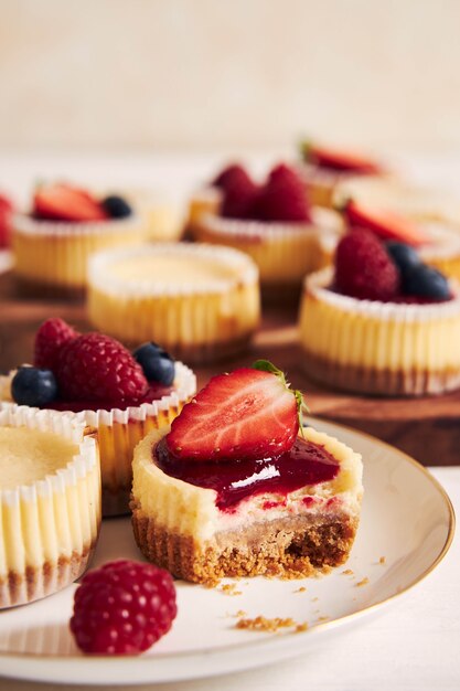 High angle shot of cheese cupcakes with fruit jelly and fruits on a wooden plate