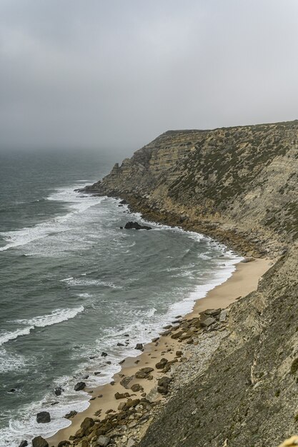 憂鬱な天候の下で海の近くの崖のハイアングルショット