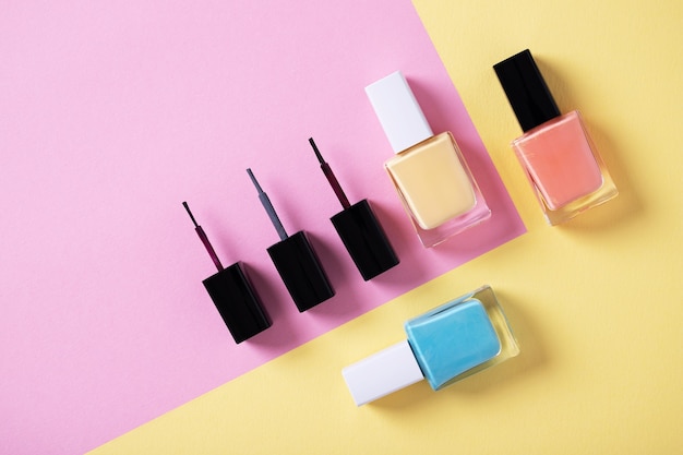 High angle shot of colorful nail polishes on a multicolor paper