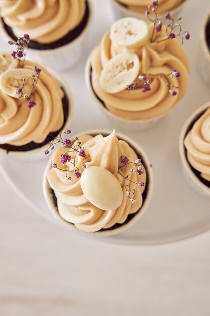 Foto gratuita colpo di alto angolo di deliziosi cupcakes al cioccolato con crema bianca
