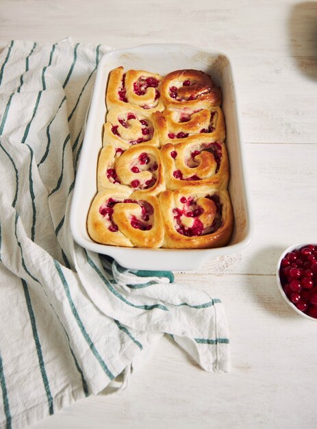 High angle shot of delicious currants snail pastries in a form on a wooden table