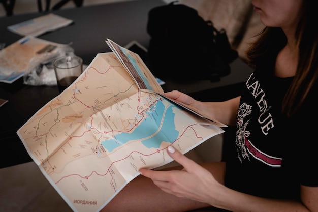 Снимок с высоким углом: женщина держит карту и читает карту, чтобы найти дорогу
