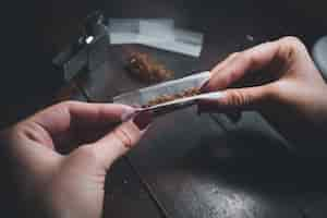 Free photo high angle shot of a female rolling a joint