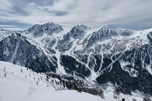 High angle shot of a forested mountain covered in snow in Col de la Lombarde - Isola