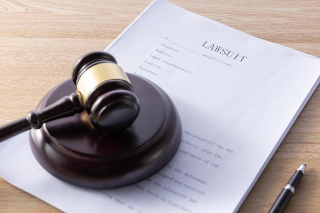 Free photo high angle shot of a gavel and lawsuit papers on a wooden surface