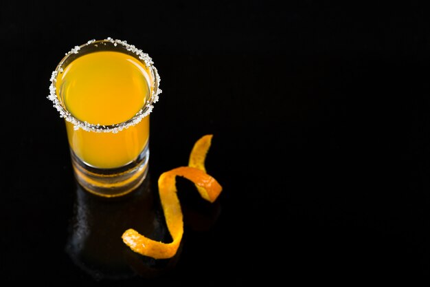Высокий угол рюмки с апельсиновым коктейлем