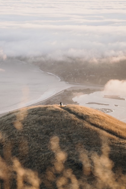 Free photo high angle shot of hills of different sizes surrounding the calm ocean