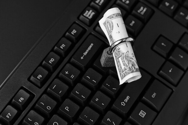 High angle shot of a lock around a dollar bill on a black laptop