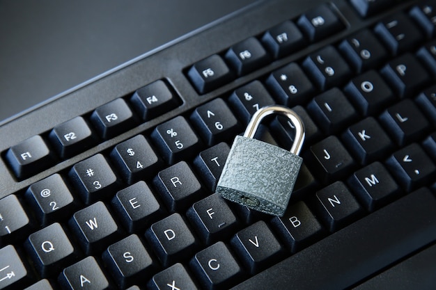 High angle shot of a lock on a black computer keyboard on a black surface