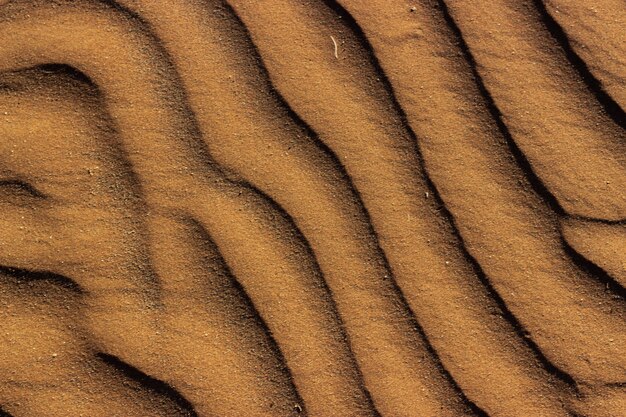 Снимок узорчатой текстуры песка под высоким углом в Намибии