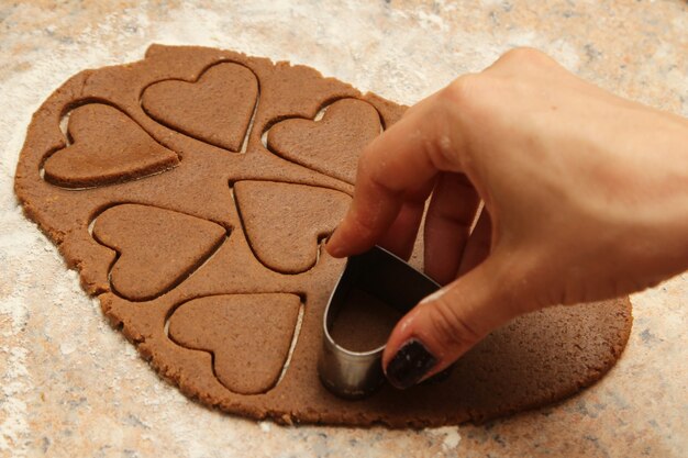 High angle shot of a person making heart-shaped cookies