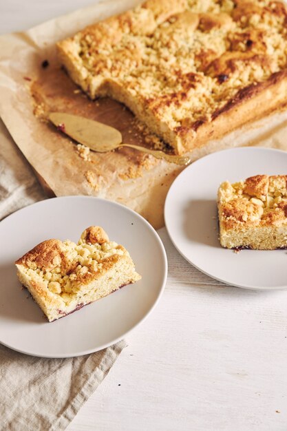 High angle shot of pieces of delicious Jerry Crumble Sheet cake on a white wood table