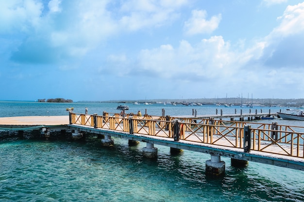 High angle shot of a pier on the seashore with a cloudy blue sky