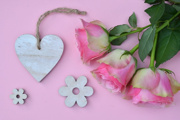 High angle shot of pink roses with other decorations on a pink surface