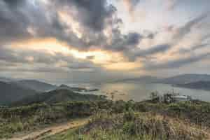 Free photo high angle shot of the plant-covered hills over the bay under the beautiful cloudy sky