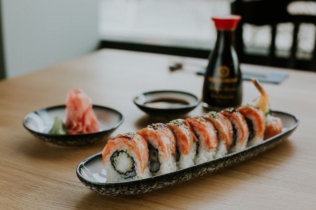 High angle shot of a plate with sushi and its ingredients on a table