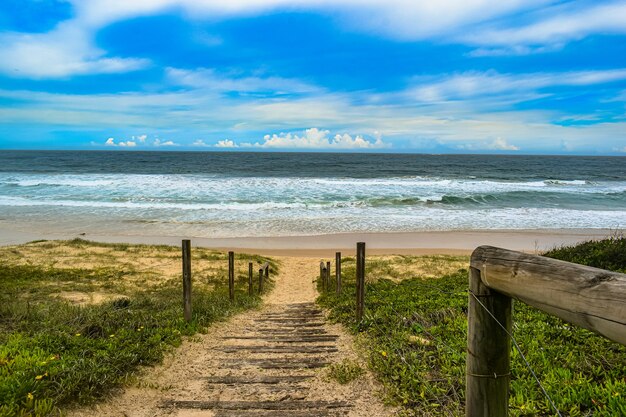 High angle shot of a road with wooden railings leading to the sea