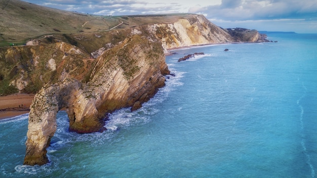 High angle shot of the rocks in the seashore of the Durdle Door in Dorset